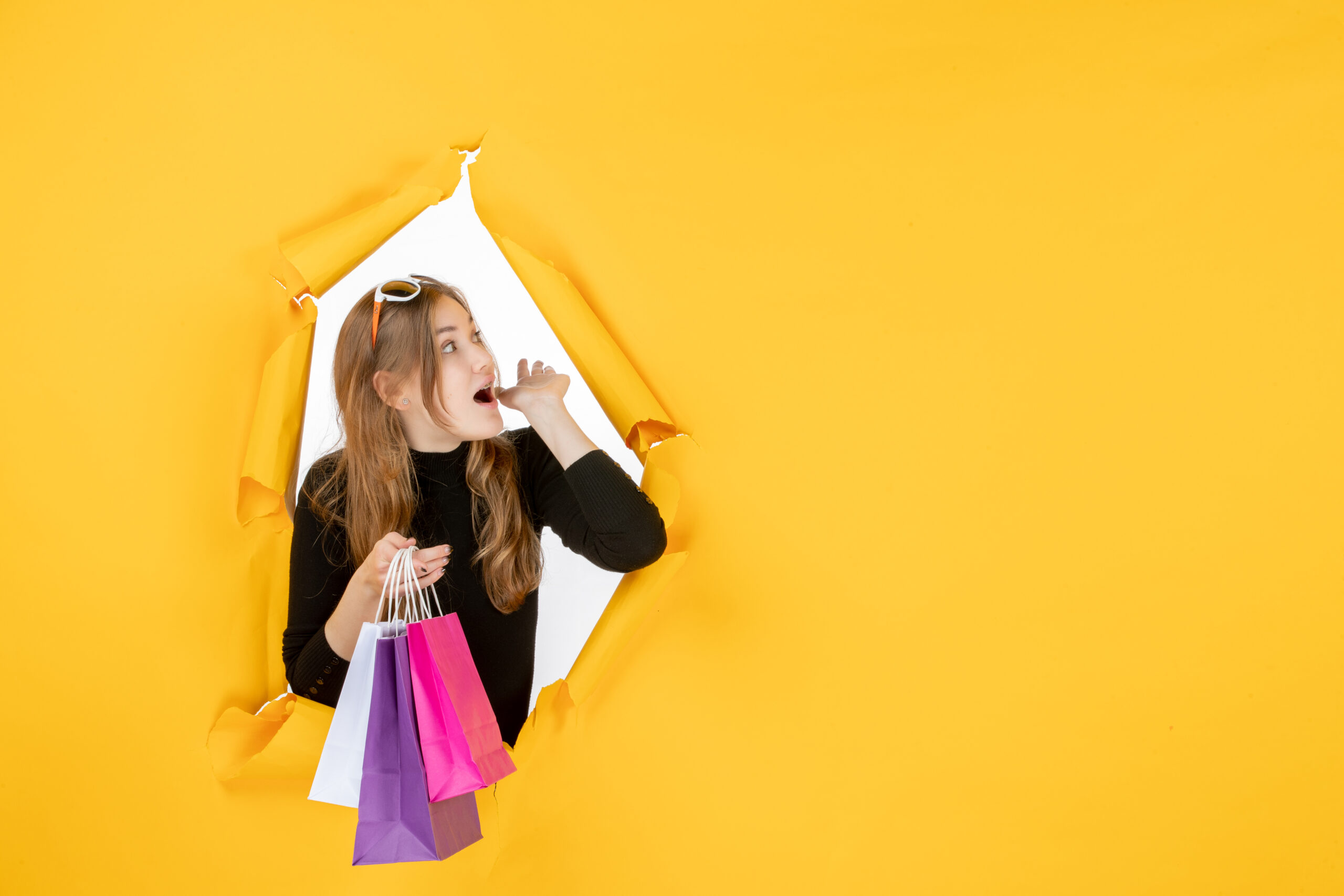 young-fashion-woman-with-shopping-bags-through-torn-paper-hole-wall Adorable Buddha Monk Figurines With Wooden Stand